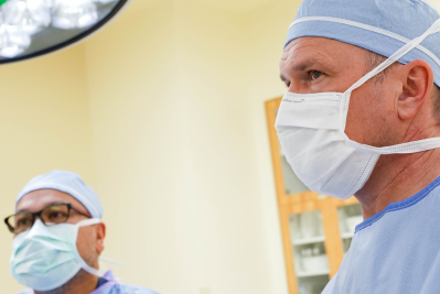 two doctors in scrubs and masks in a room