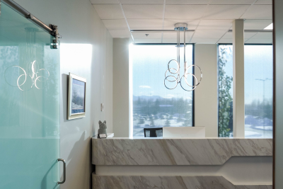 Dr Schumacher holding a white pug dog who is wearing a pearl necklace